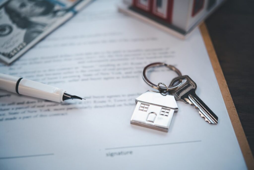 House-shaped keyring and keys resting on a signed property deed