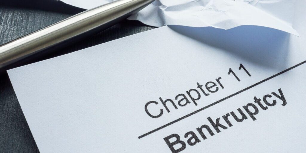 Chapter 11 bankruptcy and crumpled papers with financial statement.