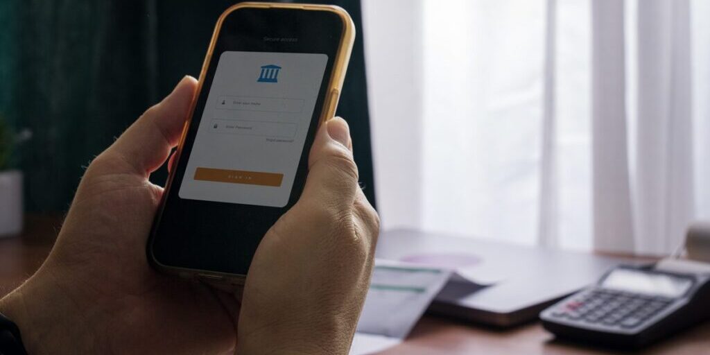 Person signing in to a banking app on a smartphone, one of the online accounts an executor may need access to