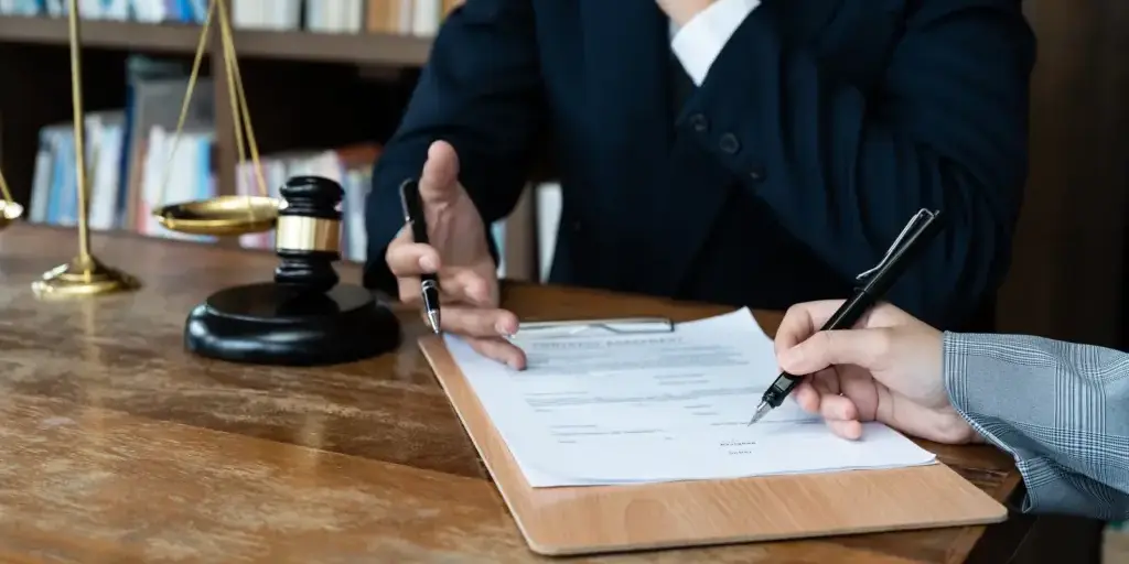 Attorney reviewing a probate document with a client at a desk in a Harris County law office